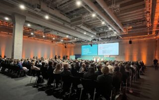 Eröffnung des Forums, mit einer Bühne und einerm Saal voller Personen.